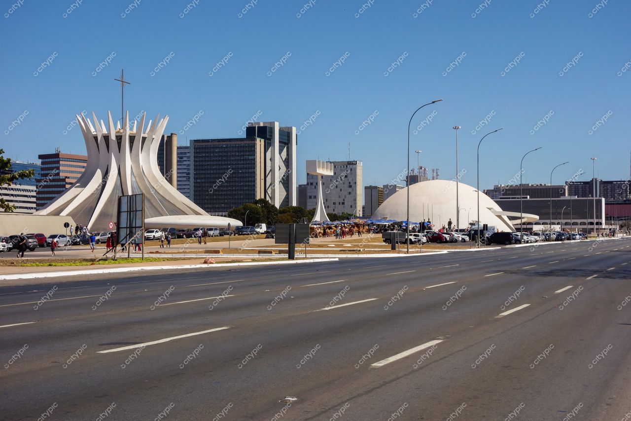 Catedral Metropolitana de Brasília em Brasília com céu claro, edifícios altos e tráfego urbano ao redor