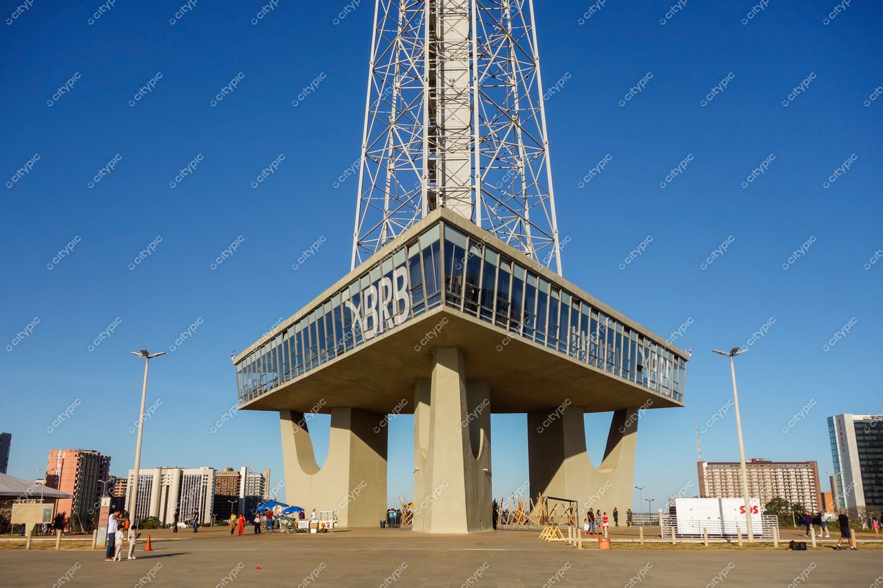 Torre de TV de Brasília em Brasília com céu azul, iluminação pública e prédios residenciais ao fundo em dia ensolarado