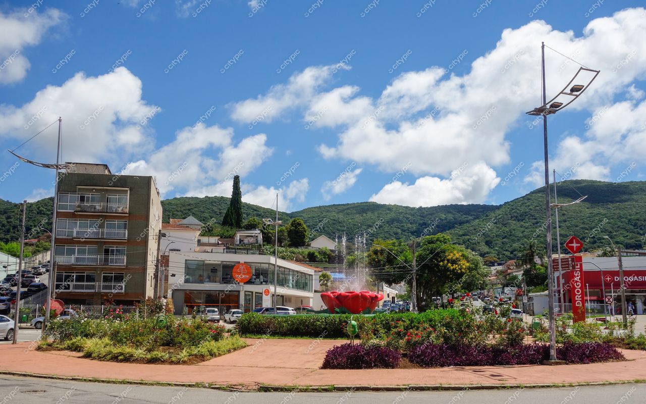 Centro de Poços de Caldas em Poços de Caldas com rotatória floral e montanhas verdes sob céu azul claro