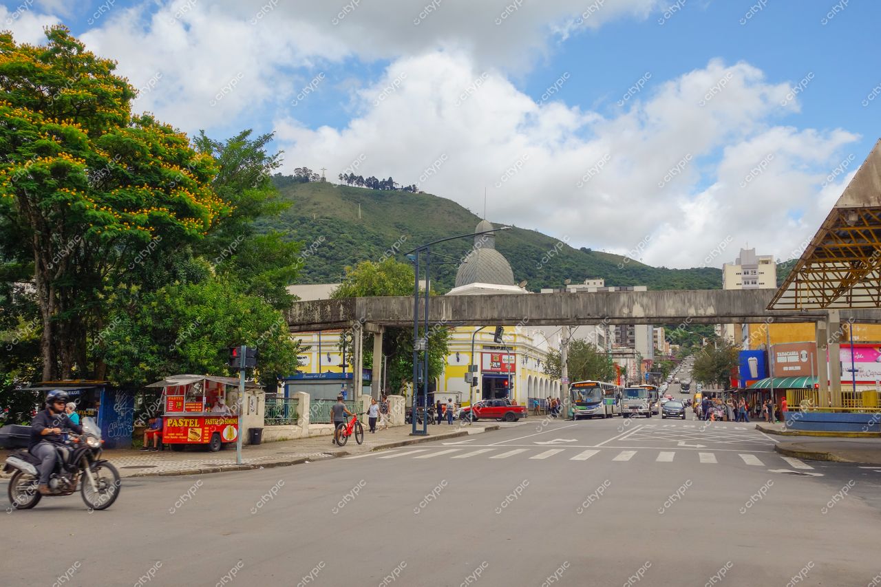 Centro de Poços de Caldas em Poços de Caldas com tráfego, construção com cúpula e montanhas verdes ao fundo