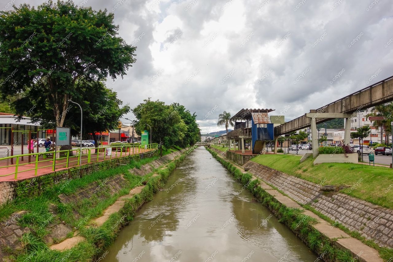 Centro de Poços de Caldas em Poços de Caldas com canal de água, calçada vermelha e céu nublado