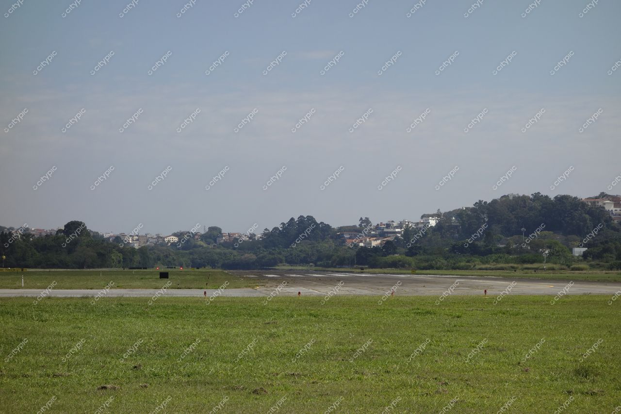 São Paulo, São Paulo, campo aberto em aeroporto com pista em primeiro plano e vegetação verde ao fundo