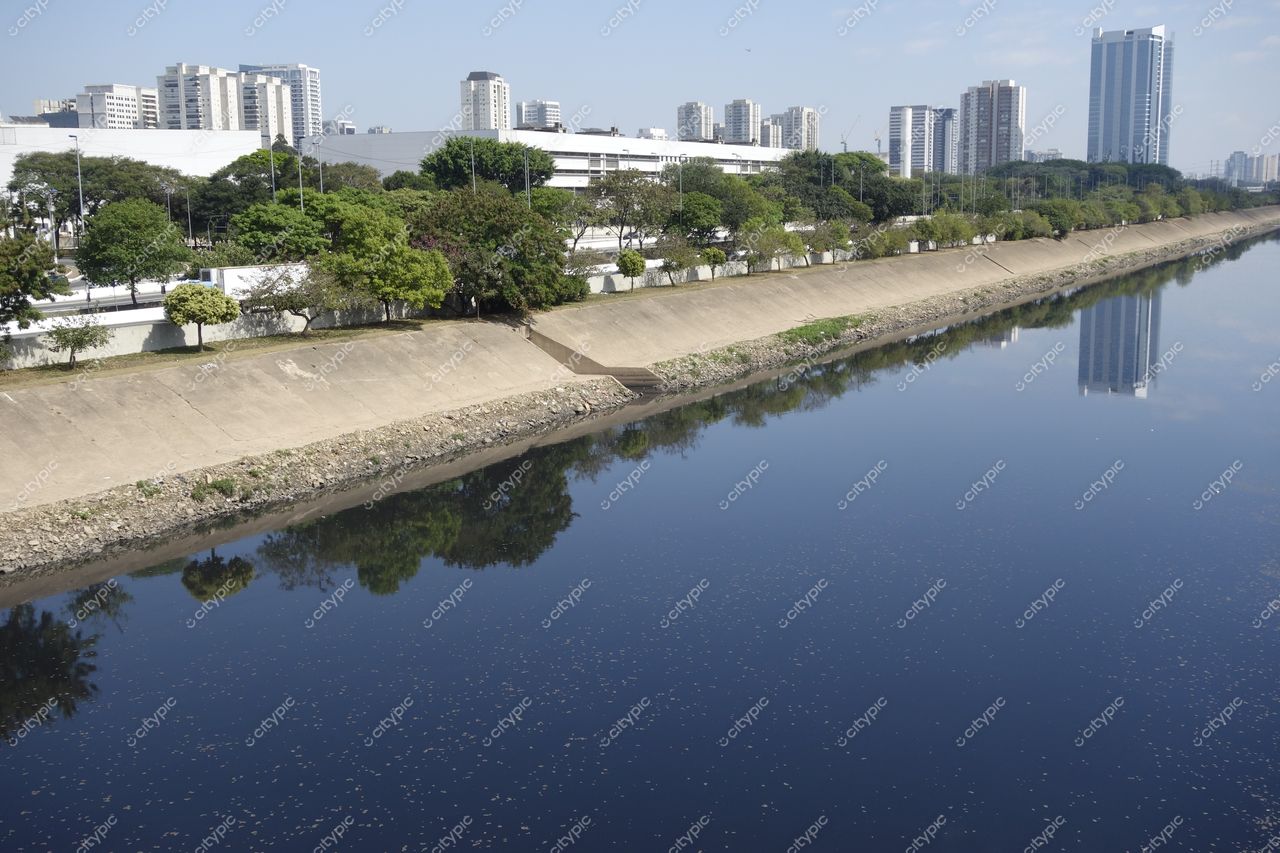 São Paulo, São Paulo, vista de canal cimentado com vegetação e edifícios modernos em dia ensolarado