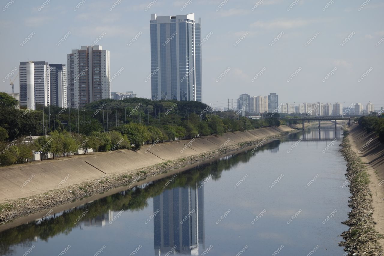São Paulo, São Paulo com edifícios altos à esquerda e rio refletindo a arquitetura em um dia ensolarado
