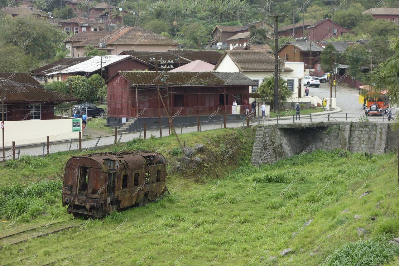 Paranapiacaba, São Paulo, locomotiva enferrujada cercada por vegetação e edificações históricas em dia nublado