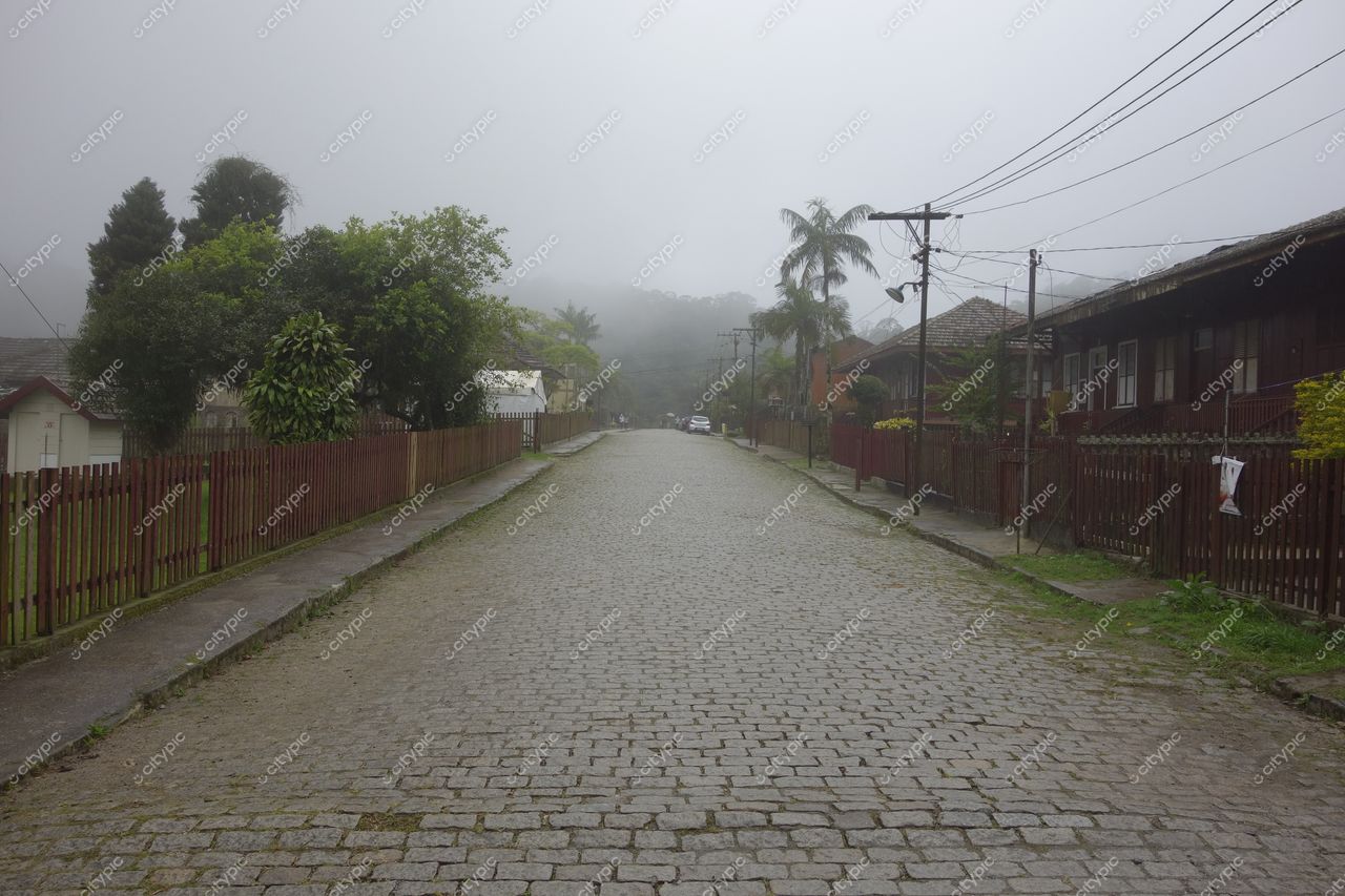 Paranapiacaba, São Paulo, rua de paralelepípedos sob nevoeiro com casas de madeira e vegetação densa