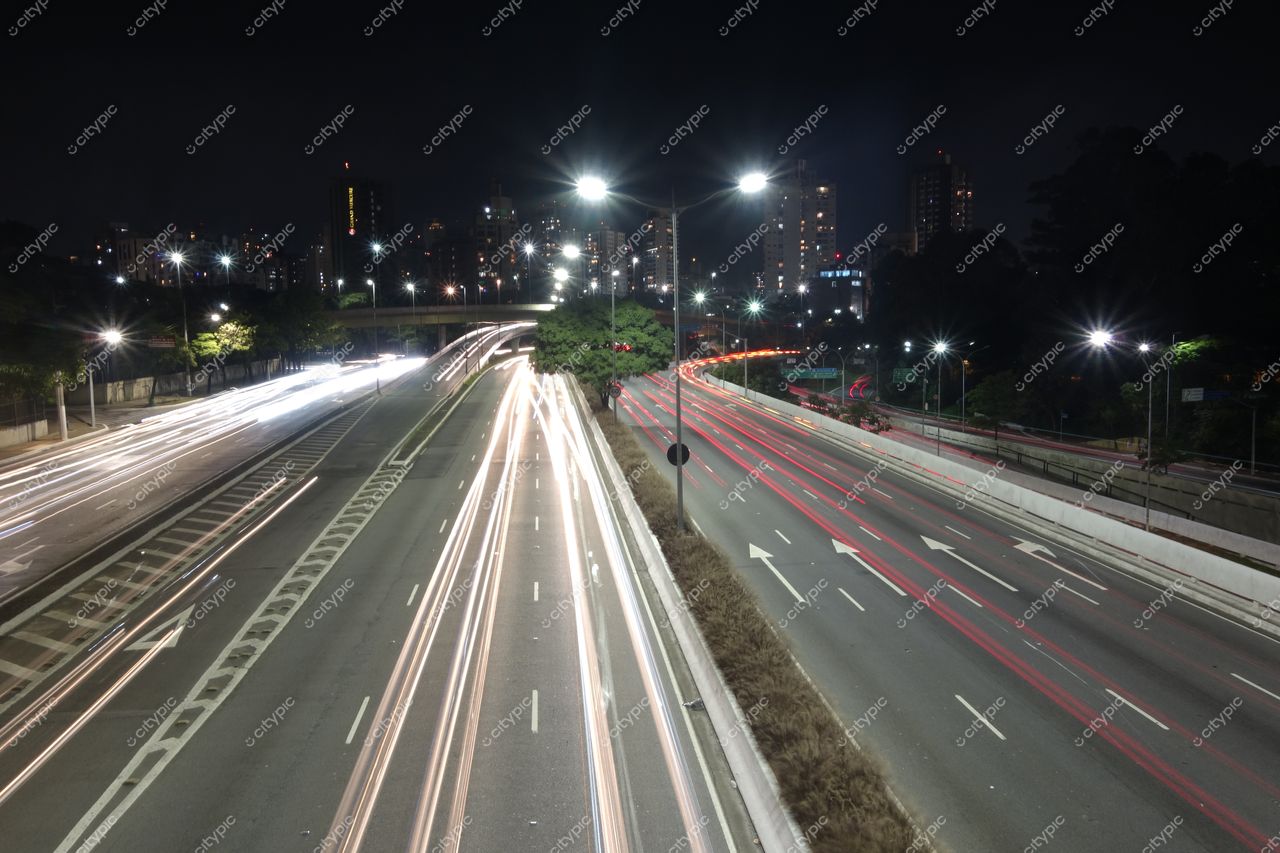 São Paulo, São Paulo, vista noturna da avenida com tráfego intenso e silhueta de edifícios iluminados ao fundo