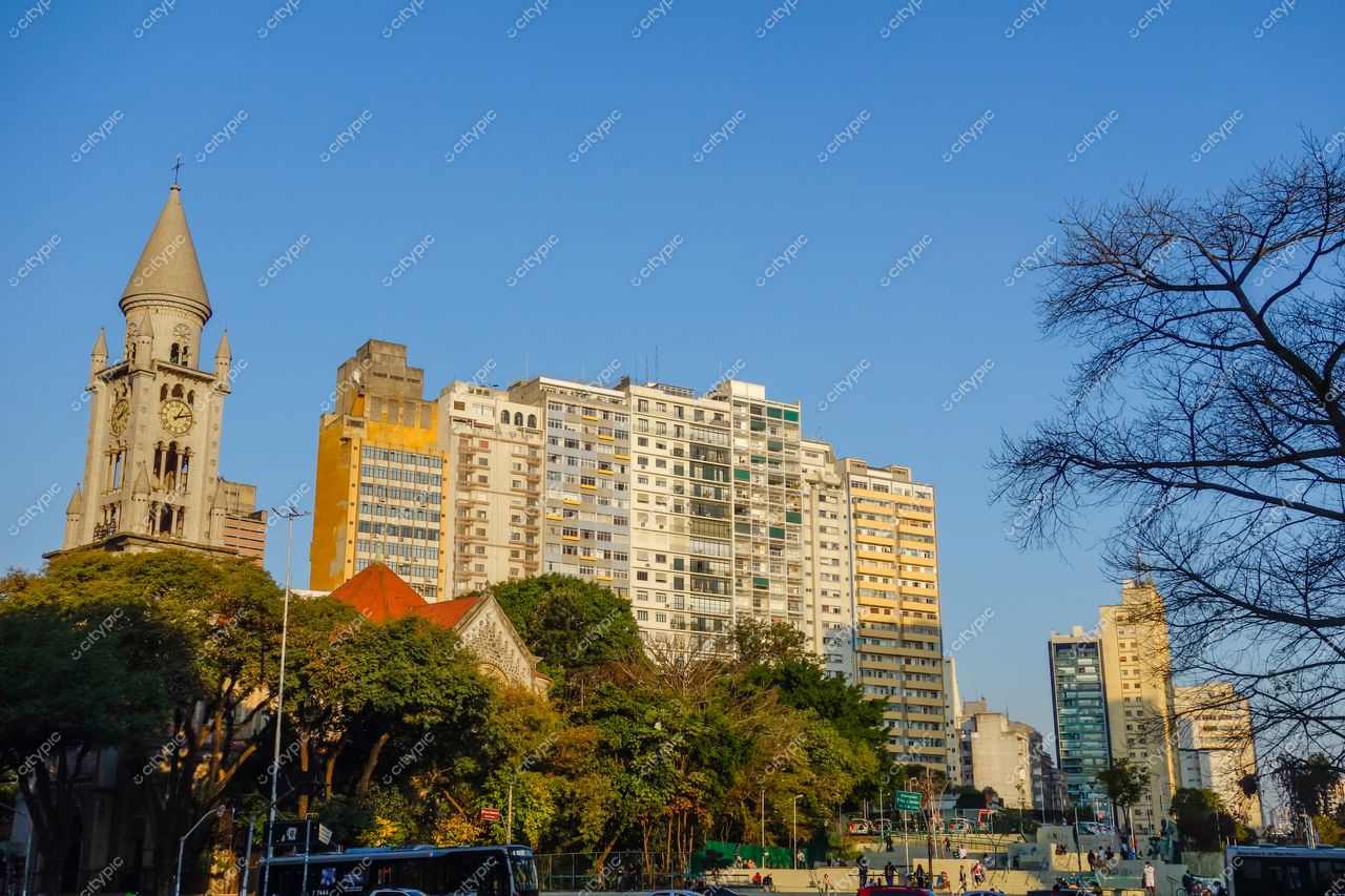São Paulo, São Paulo, vista urbana com torre de relógio clássica e prédios modernos ao entardecer com vegetação