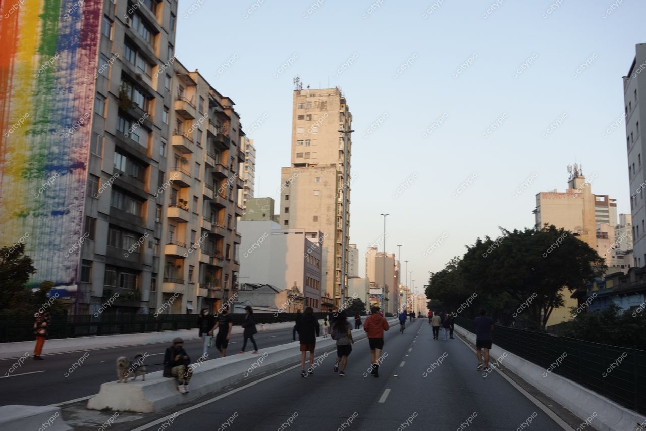 Elevado Presidente João Goulart em São Paulo com mural colorido e calçada movimentada durante o pôr do sol