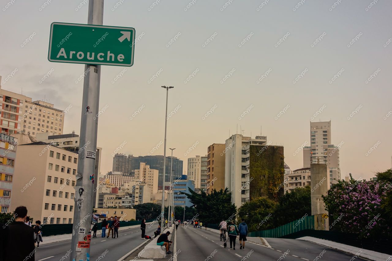 Elevado Presidente João Goulart em São Paulo ao entardecer com sinal verde para Arouche e edifícios variados