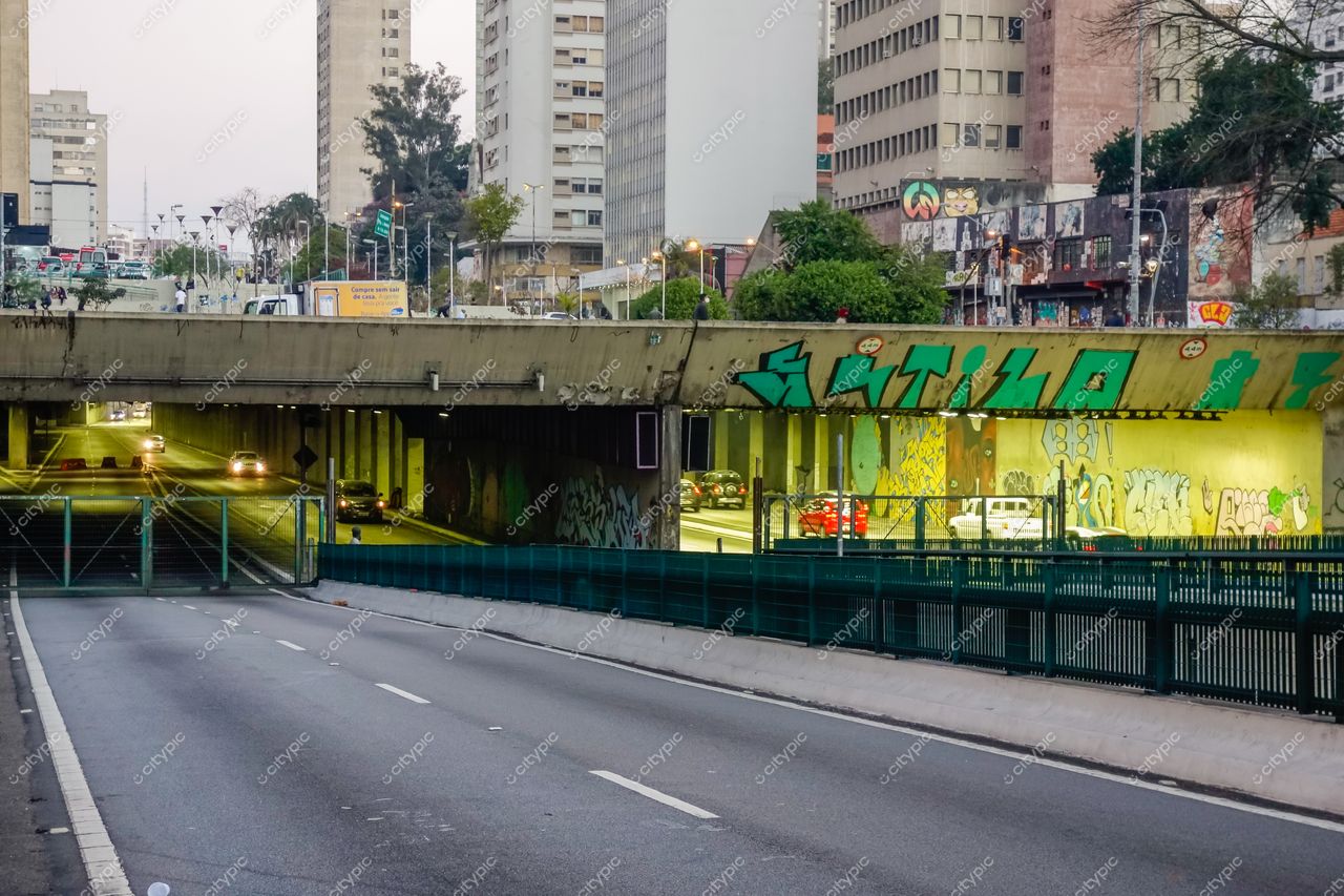 Elevado Presidente João Goulart em São Paulo durante o crepúsculo com túnel iluminado e grafites coloridos na paisagem urbana