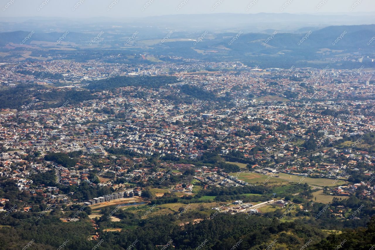 Atibaia, São Paulo vista aérea com densa malha urbana e vegetação intercalada em dia ensolarado e céu limpo