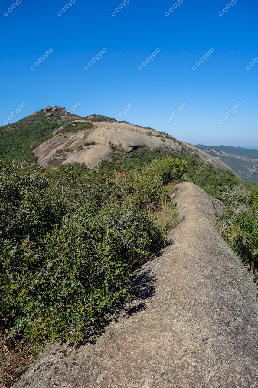 Atibaia, São Paulo vista panorâmica de formação rochosa com vegetação baixa e céu azul claro sem nuvens