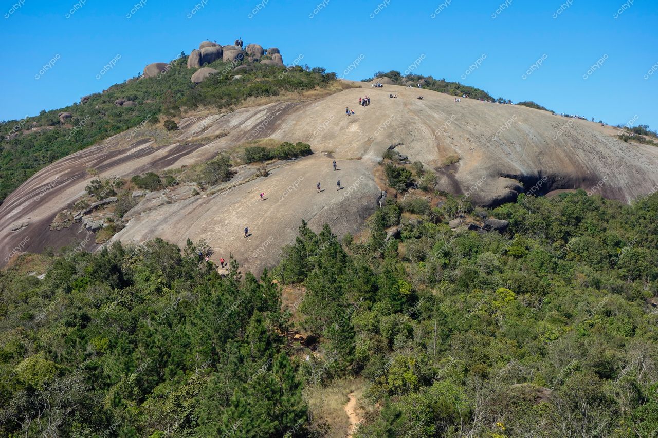Atibaia, São Paulo vista panorâmica da Pedra Grande com pessoas caminhando em dia ensolarado e céu azul claro