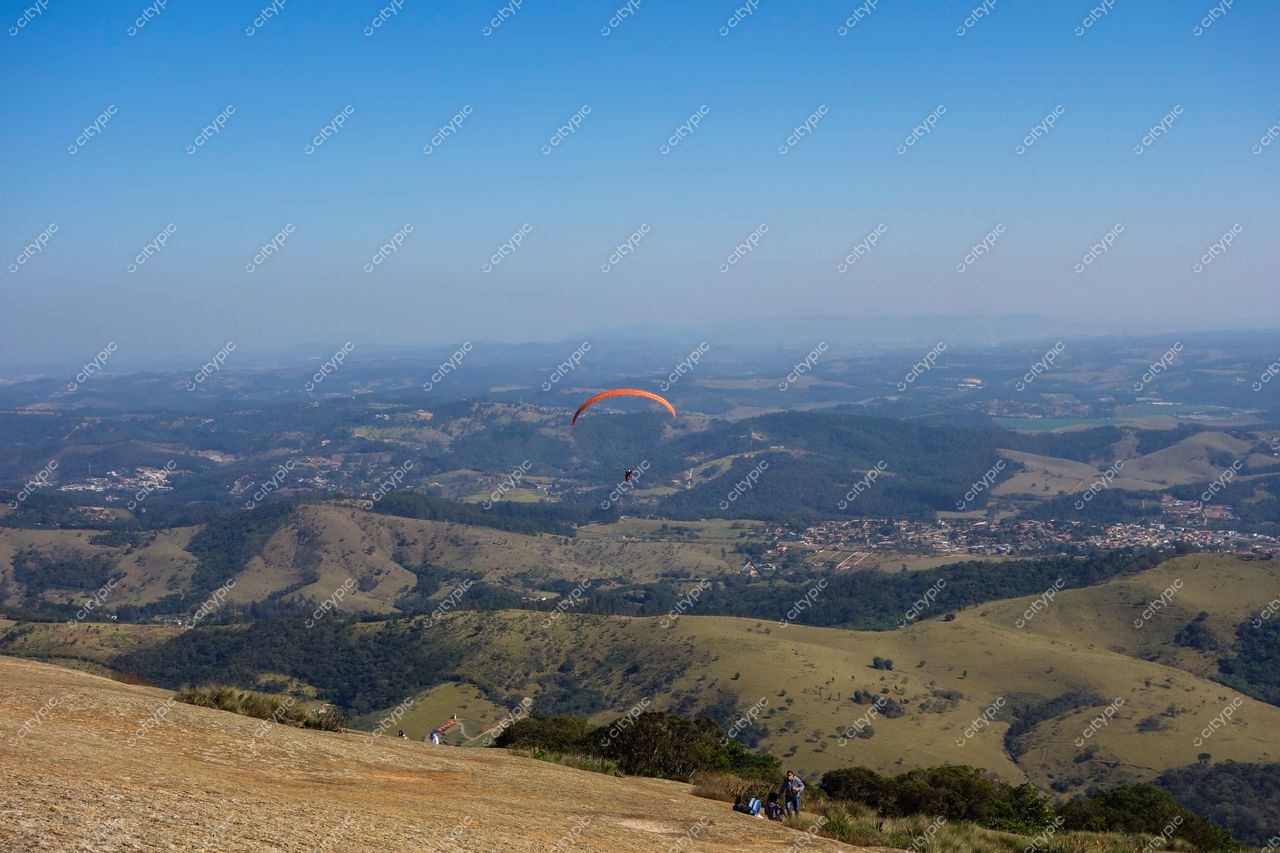 Atibaia, São Paulo vista panorâmica com parapente em voo sobre colinas verdes e pessoas explorando rochas