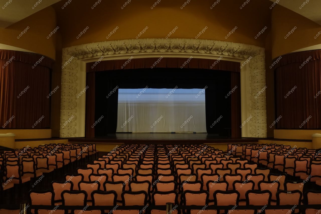 Rio de Janeiro, Rio de Janeiro, interior de teatro com palco amplo, cortinas marrons e cadeiras pink em iluminação suave