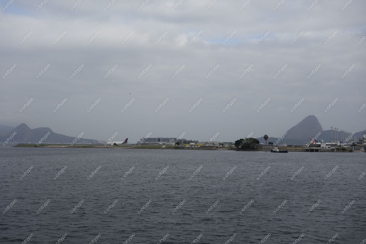 Rio de Janeiro, Rio de Janeiro vista do Aeroporto Santos Dumont com avião estacionado e montanhas ao fundo em dia nublado