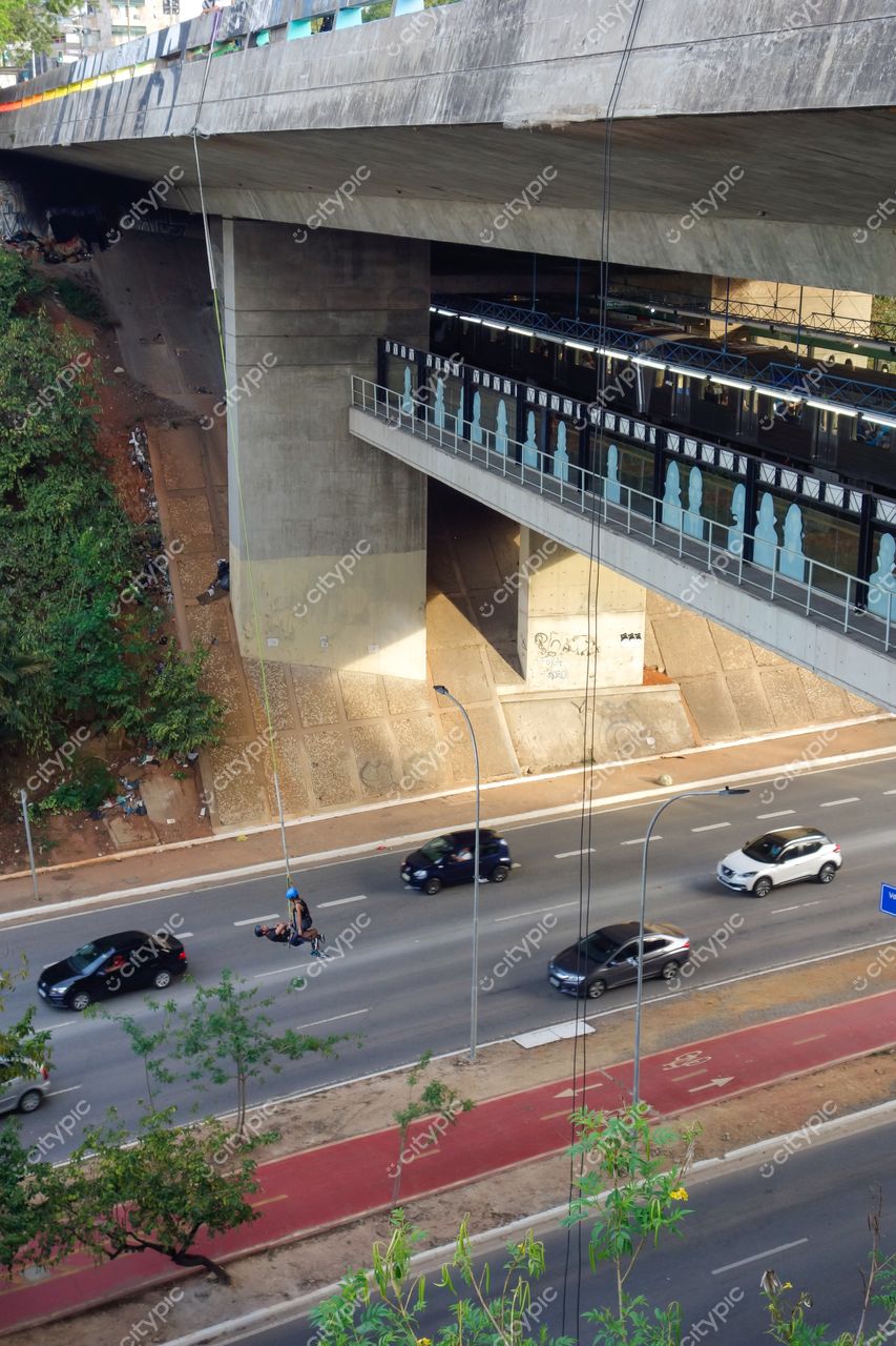 São Paulo, São Paulo, vista diurna do metrô elevado com tráfego intenso e vegetação na encosta à esquerda