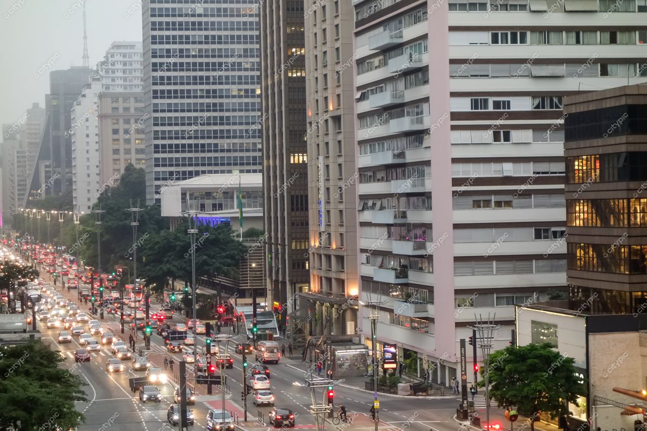 São Paulo, São Paulo, avenida movimentada ao crepúsculo com tráfego intenso e edifícios de vidro e concreto