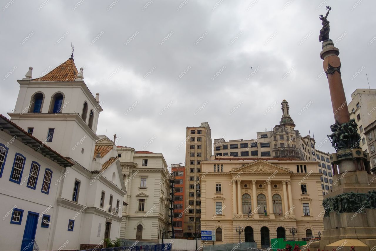 São Paulo, São Paulo, vista urbana com construção colonial à esquerda e edifício clássico à direita sob céu nublado