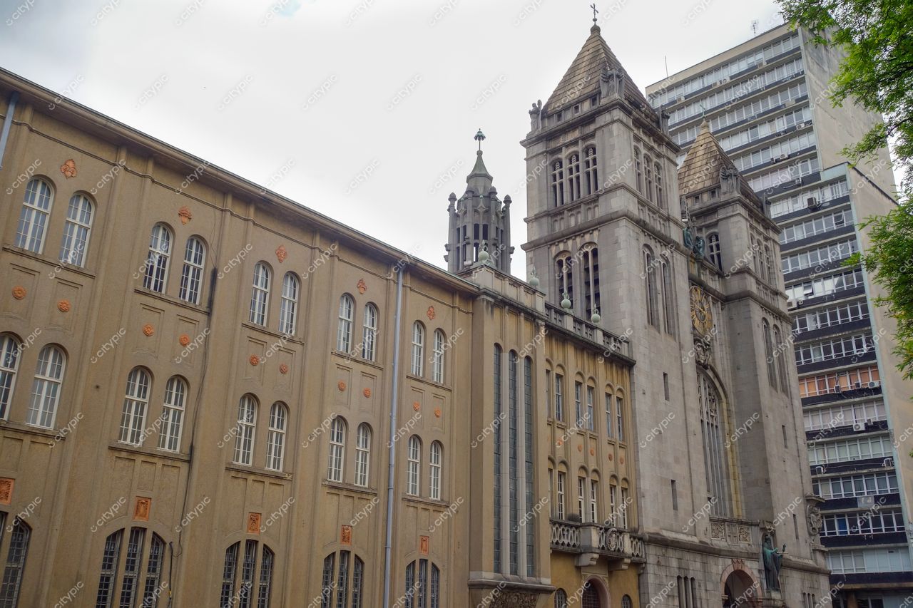 São Paulo, São Paulo, edifício histórico com torres ornamentais e janelas laranja contrastando com moderno ao fundo