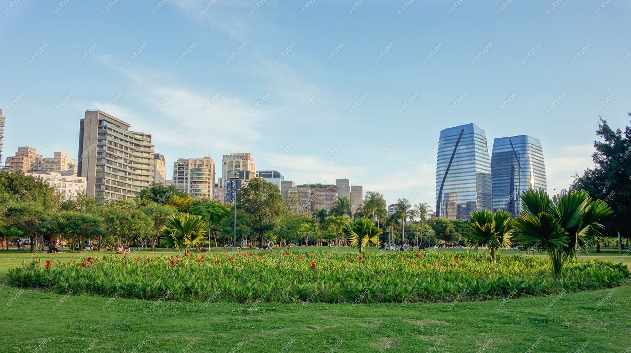 São Paulo, São Paulo, parque urbano com gramado verde e flores vermelhas sob luz suave do final da tarde