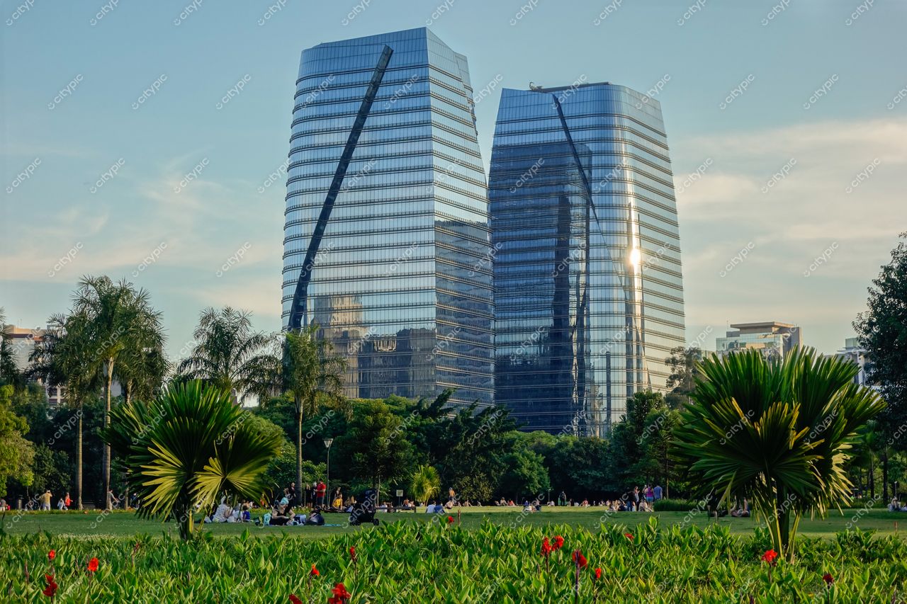 São Paulo, São Paulo, edifícios altos com fachadas de vidro em espaço verde urbano ao entardecer com pessoas e vegetação