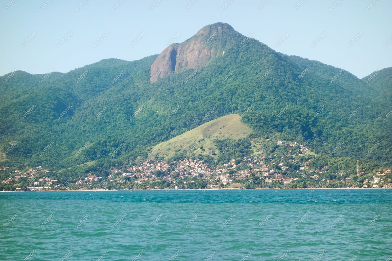 Ilhabela, São Paulo vista panorâmica com monte rochoso ao fundo e área urbana à esquerda em dia claro