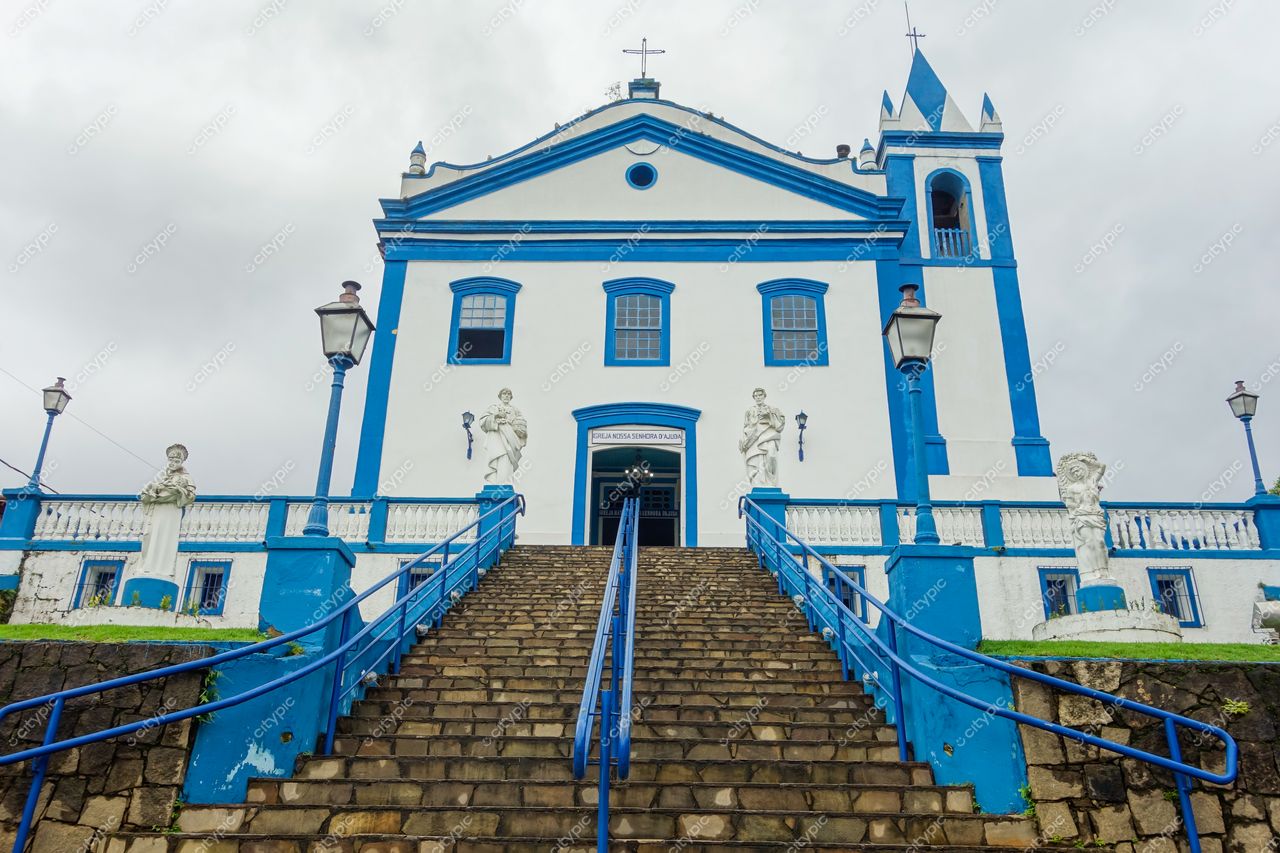 Ilhabela, São Paulo, igreja colonial com paredes brancas e azuis sob céu nublado em ambiente tranquilo e natural