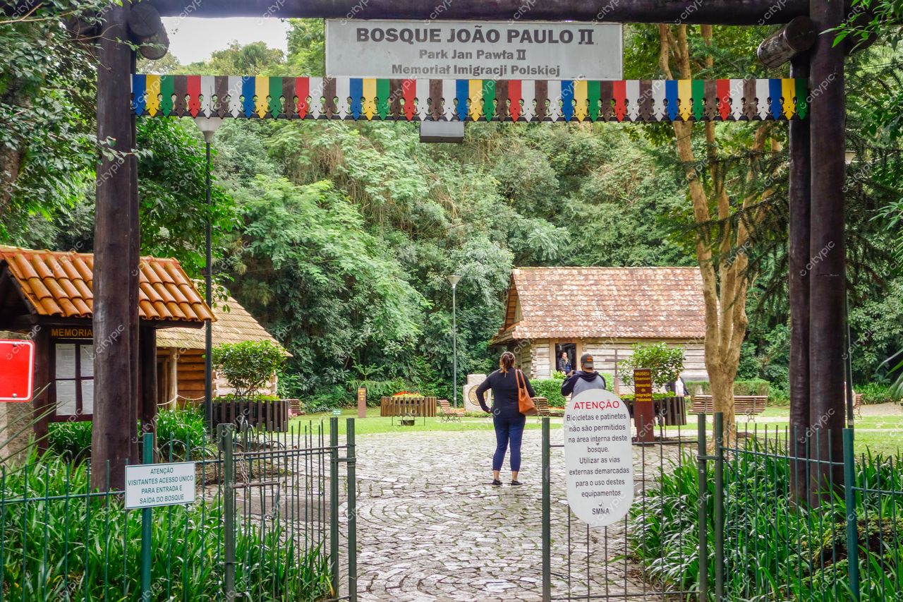 Bosque do Papa João Paulo II em Curitiba com portão de madeira, bandeirinhas coloridas e iluminação suave em dia nublado