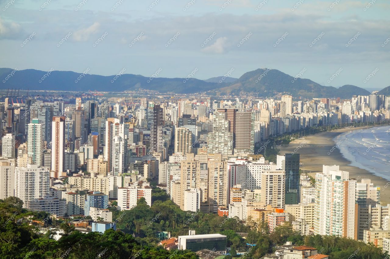 Santos, São Paulo, vista panorâmica em dia ensolarado com arranha-céus à beira-mar e montanhas ao fundo