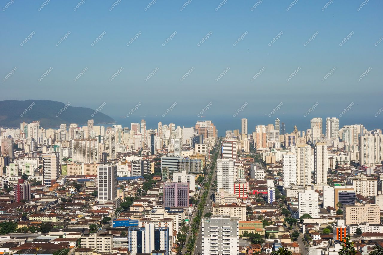 Santos, São Paulo, vista panorâmica com edifícios altos refletindo luz do sol e vegetação entre construções urbanas