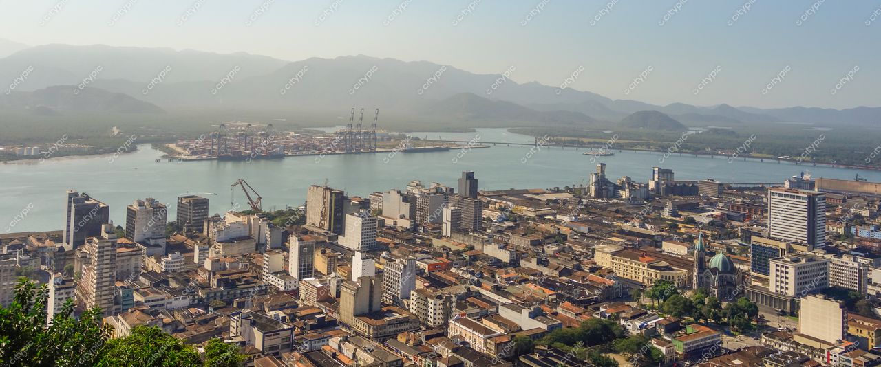 Santos, São Paulo, vista panorâmica com vegetação exuberante e edifícios urbanos próximos ao porto em luz suave