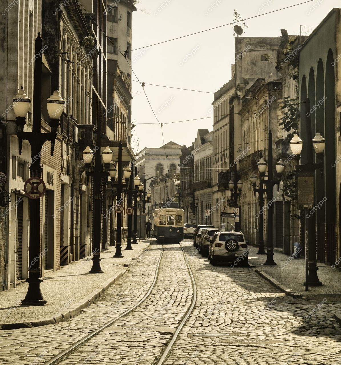 Santos, São Paulo, rua histórica com bonde amarelo em paralelepípedos e luz suave da manhã sobre arquitetura colonial
