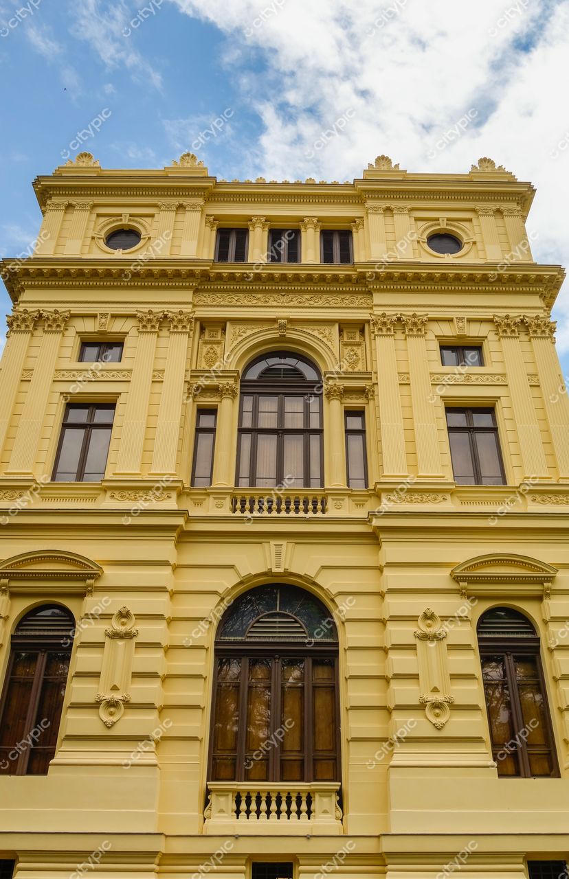 São Paulo, São Paulo, fachada de edifício histórico amarelo com janelas em madeira e ornamentos clássicos em ambiente urbano