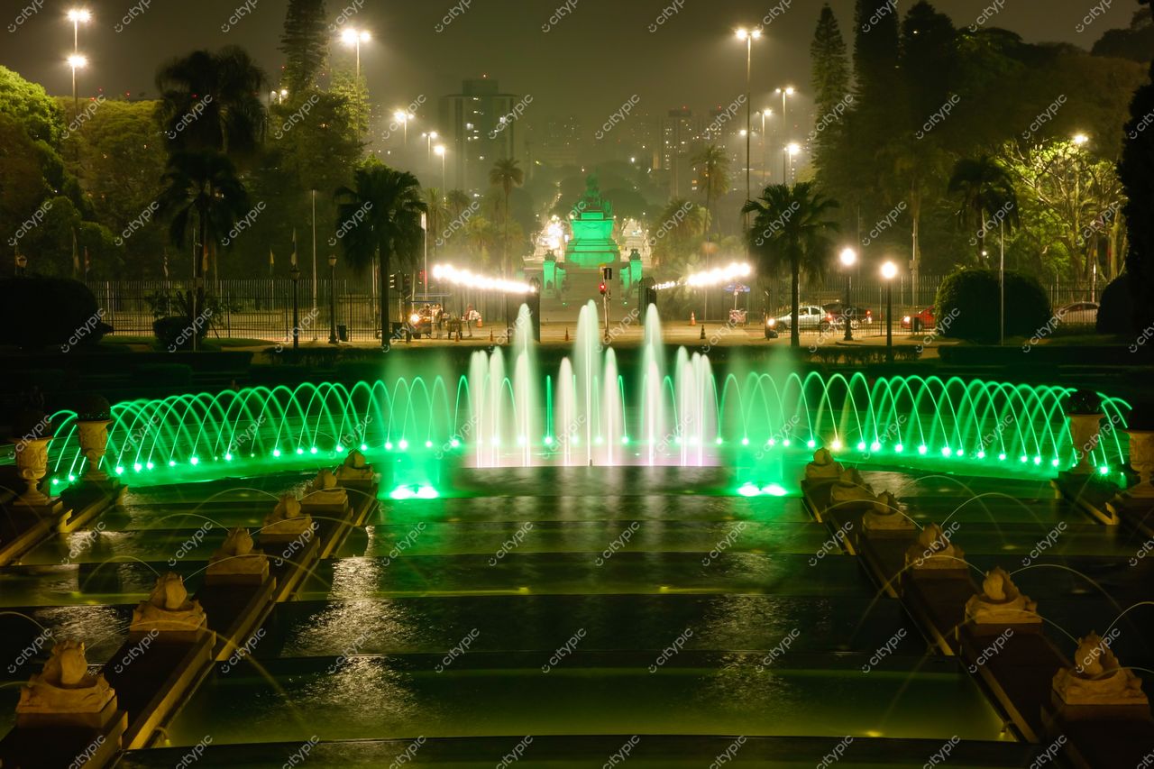 São Paulo, São Paulo, fonte iluminada em verde à noite com vegetação e tráfego urbano ao fundo