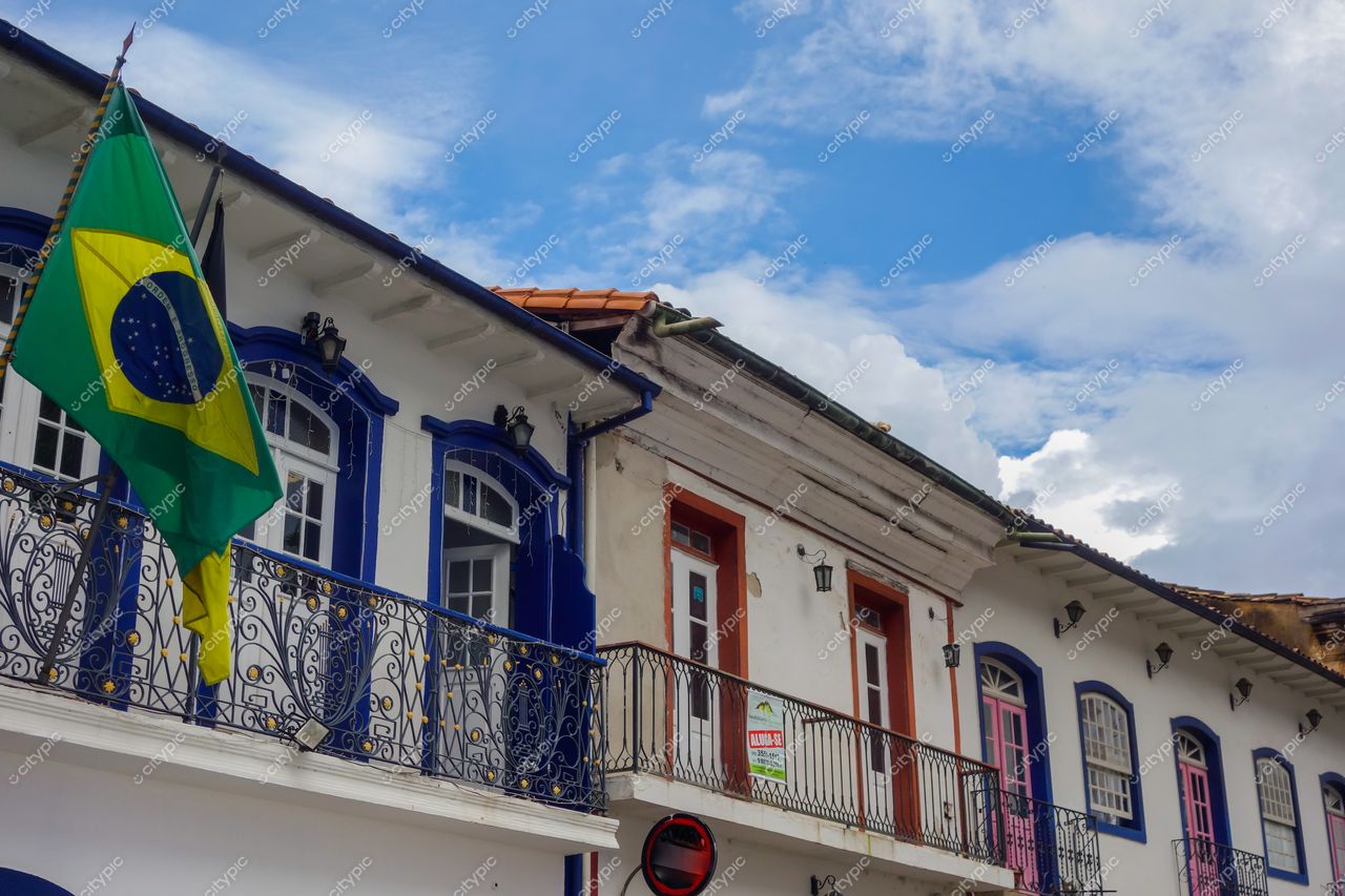 Ouro Preto, Minas Gerais, arquitetura colonial com fachadas brancas e detalhes em azul, bandeira do Brasil ao vento