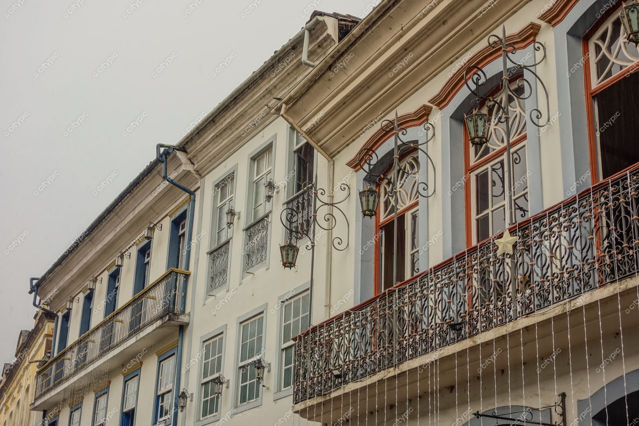 Ouro Preto, Minas Gerais, fachada de edifícios históricos com janelas elaboradas e varandas em dia nublado e iluminação suave