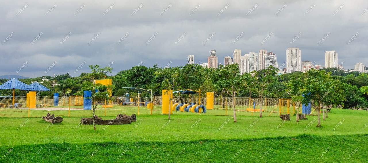São Paulo, São Paulo, parque com gramado verde e estruturas recreativas coloridas sob céu nublado e prédios altos ao fundo