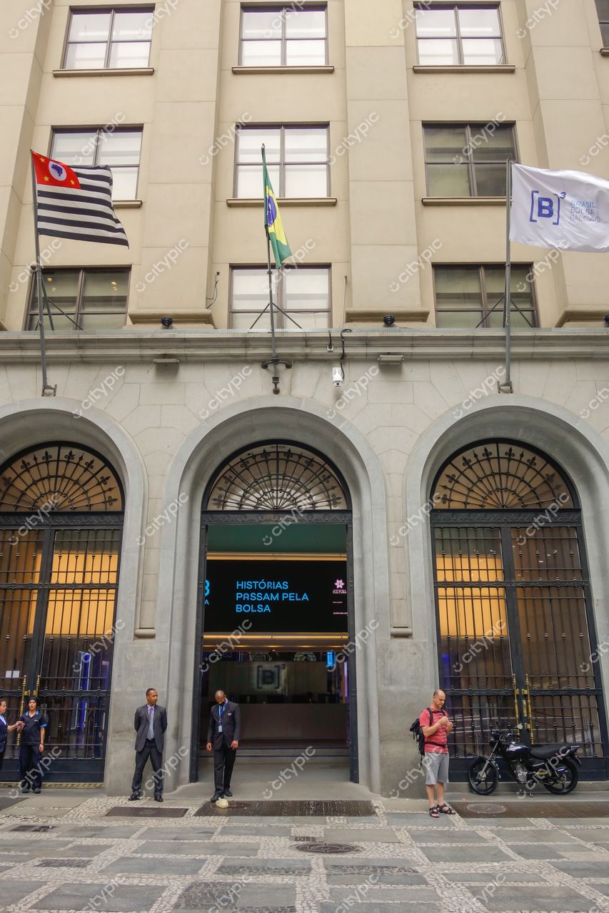 B3 – Museu da Bolsa do Brasil em São Paulo com fachada clara, bandeiras hasteadas e dia nublado