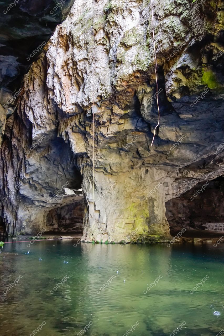 Socorro, São Paulo, caverna com bloco de pedra irregular e paredes rochosas úmidas em iluminação suave