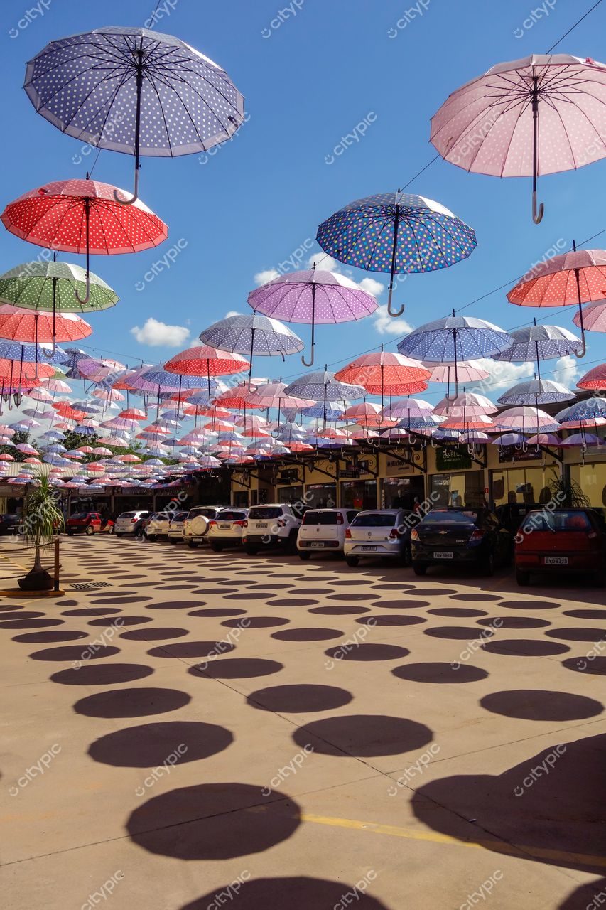 Socorro, São Paulo, guarda-chuvas coloridos suspensos sobre área pavimentada em dia ensolarado com céu azul