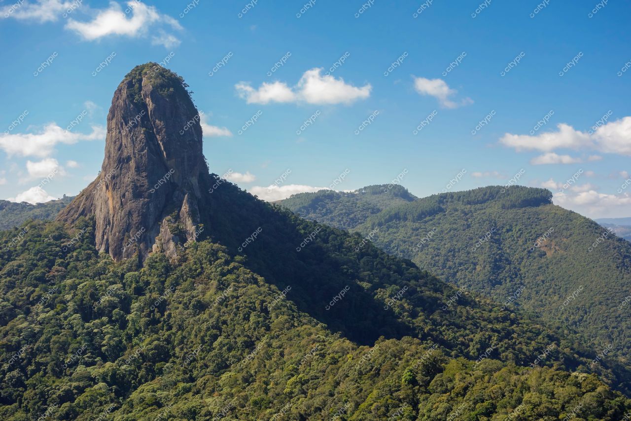 São Bento do Sapucaí, São Paulo, vista da Pedra do Baú em dia ensolarado com céu azul e vegetação densa