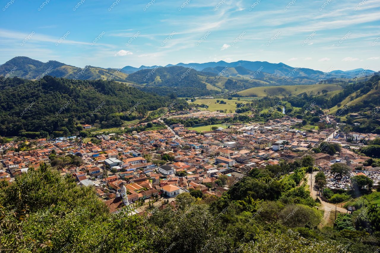 São Bento do Sapucaí, São Paulo, vista panorâmica em dia ensolarado com casas de telhado cerâmico e montanhas ao fundo