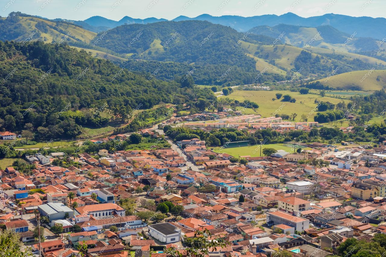 São Bento do Sapucaí, São Paulo, vista aérea em dia ensolarado com casas de telhados vermelhos e montanhas ao fundo
