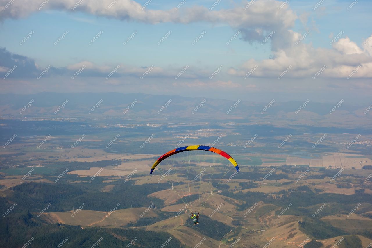 São Bento do Sapucaí, São Paulo, parapente colorido sobre vales e colinas em dia ensolarado com céu claro