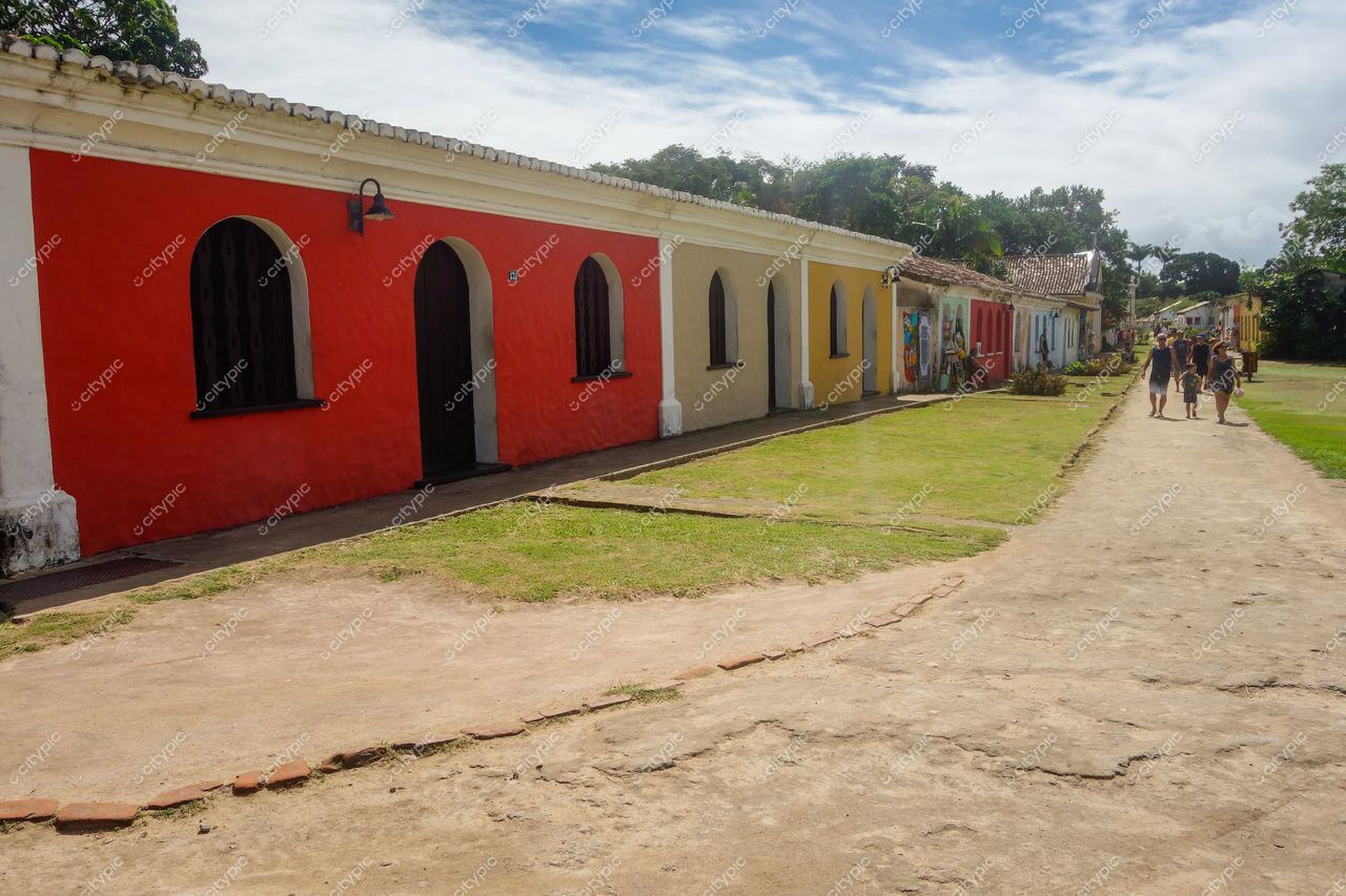 Centro Histórico de Porto Seguro em dia ensolarado com calçadão, edifícios coloridos e vegetação tropical ao redor