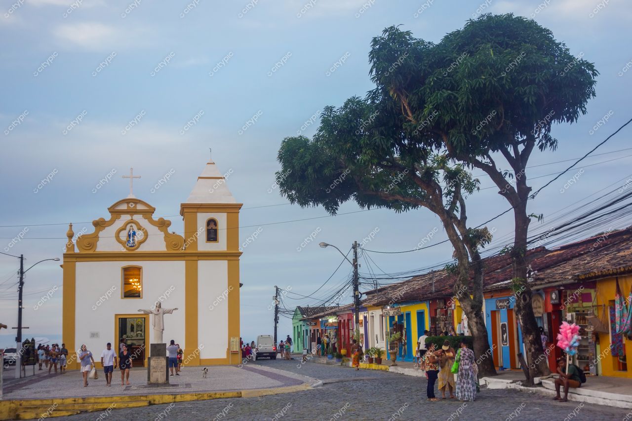 Igreja Nossa Senhora da Luz em Morro de São Paulo com iluminação suave ao pôr do sol e vegetação densa ao fundo
