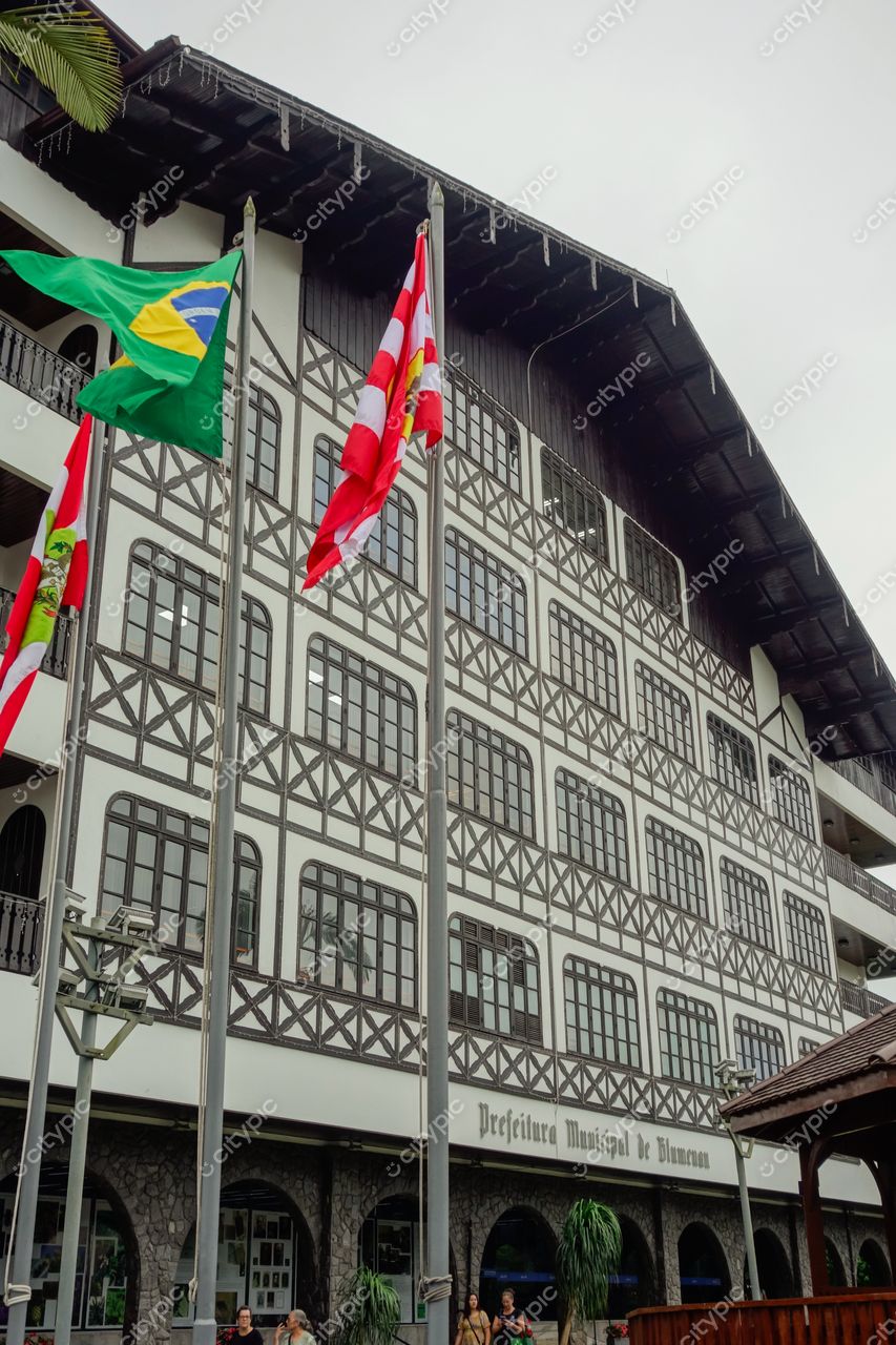 Blumenau, Santa Catarina, fachada da Prefeitura Municipal em dia nublado com vegetação e pedestres ao redor