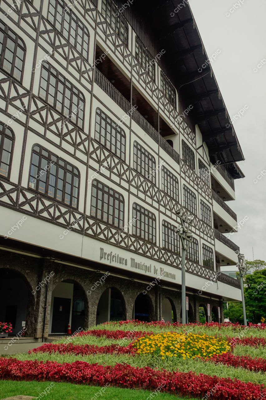 Blumenau, Santa Catarina, Prefeitura Municipal em estilo enxaimel com jardim florido sob céu nublado e iluminação suave